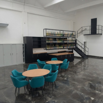 Area lounge con bar e tavoli rotondi